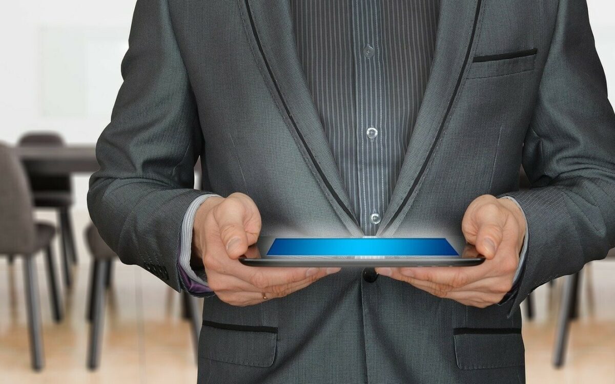 Ein Mann mit Tablet in der Hand bei einer Tagung Ein Mann mit Tablet in der Hand bei einer Tagung